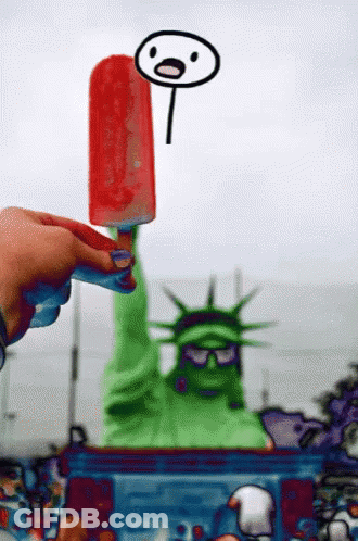 Person Holding Popsicle Over Statue Of Liberty GIF