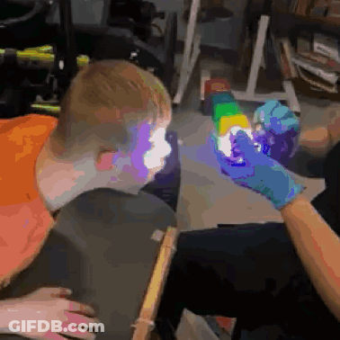 Person Holding Rainbow Cube In Front Of Boy's Face GIF
