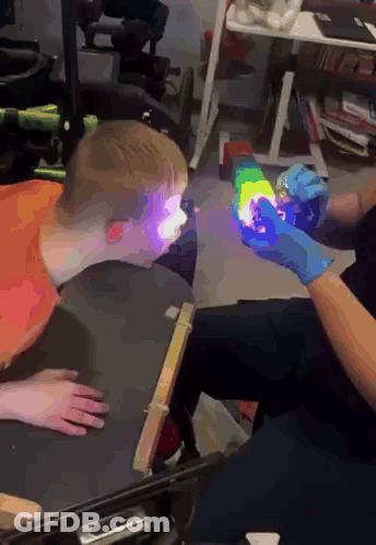 Person Holding Rainbow Object In Front Of Child GIF