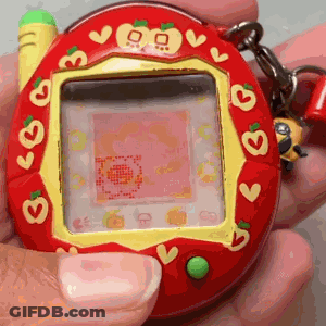 Person Holding Red And Yellow Tamagotchi With Hearts GIF