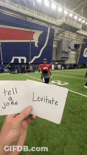 Person Holding Sign Saying Tell A Joke And Levitate GIF