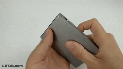 Person Holding Small Gray Object GIF