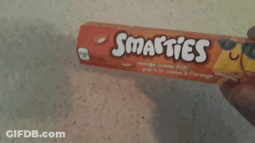 Person Holding Smarties Orange Cream Pop Bar GIF