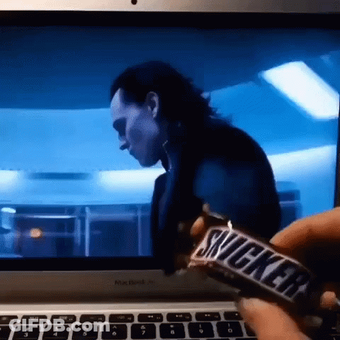 Person Holding Snickers Bar In Front Of Computer GIF