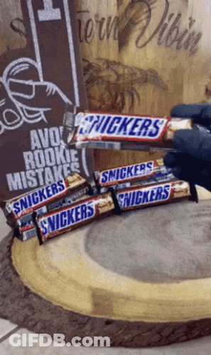 Person Holding Snickers Stack, Avoid Rookie Mistakes Sign GIF