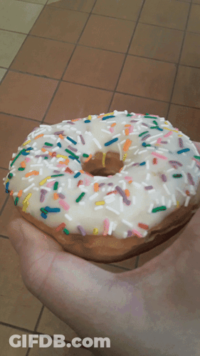 Person Holding Sprinkled Donut GIF
