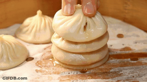 Person Holding Stack Of Dumplings GIF