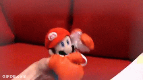 Person Holding Stuffed Mario Doll On Red Couch GIF