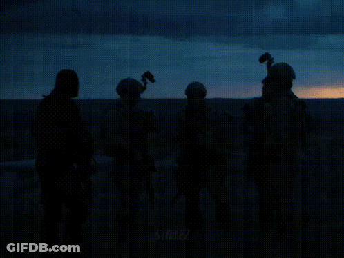 Person Holding Suited Cartoon With Two Guns GIF