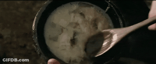 Person Holding Wooden Spoon Over Bowl Of Soup GIF