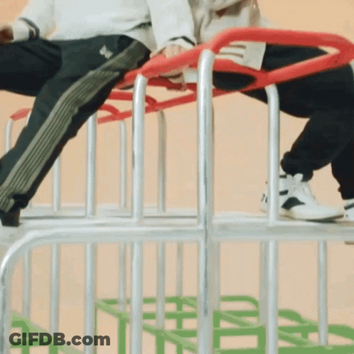 Person In Adidas Pants Sitting On Metal Fence GIF