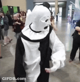 Person In Black And White Clown Costume In Crowd GIF