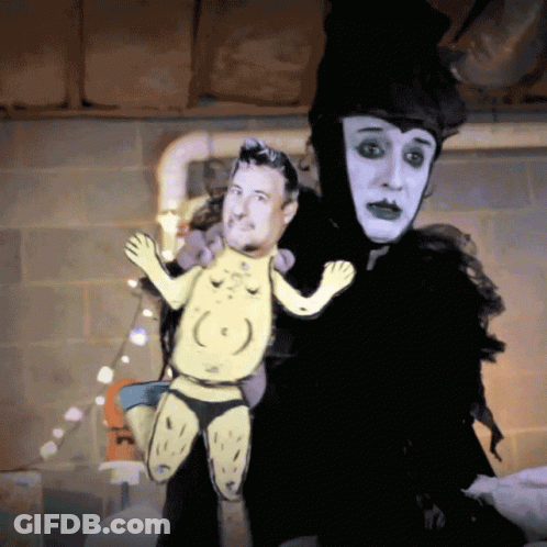 Person In Black And White Costume Holding Puppet GIF
