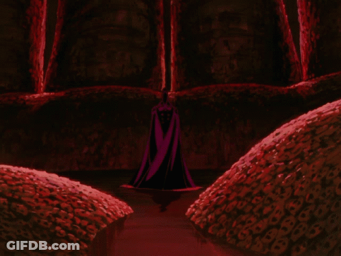 Person In Black Cape Stands In Dark Room GIF