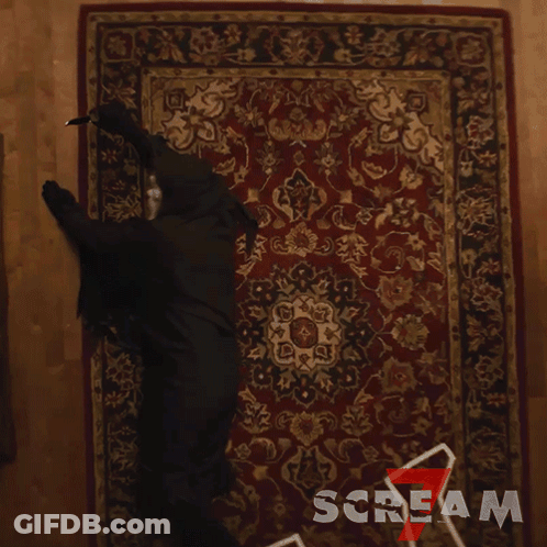 Person In Black Costume Crawling On Scream Rug GIF