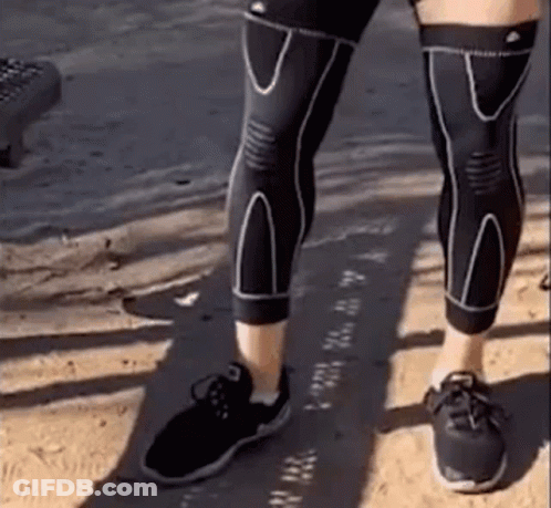 Person In Black Knee Braces And Shoes On Sandy Beach GIF