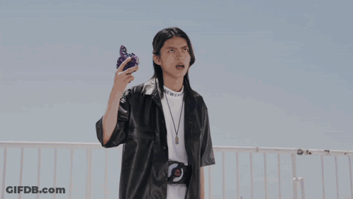 Person In Black Leather Jacket Holding Purple Object GIF