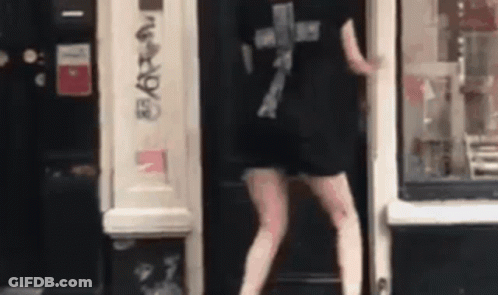 Person In Black Shirt Standing In Front Of Store Door GIF