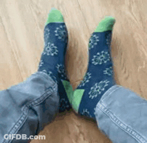 Person In Blue And Green Socks With Snowflakes GIF
