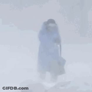 Person In Blue Coat Walking Through Snow GIF