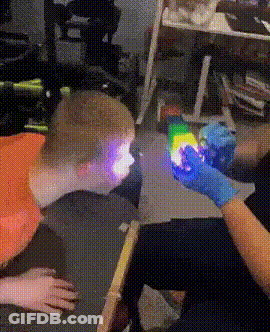 Person In Blue Gloves Holding Rainbow Light GIF