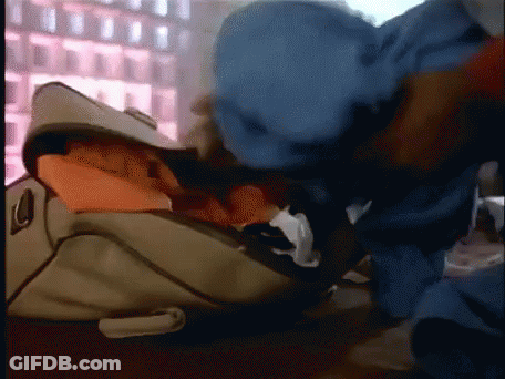 Person In Blue Hat Looking Into Suitcase Full Of Clothes GIF