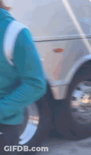 Person In Blue Jacket Next To Silver Vehicle GIF