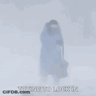 Person In Blue Jacket Walking Through Snow With Bag GIF