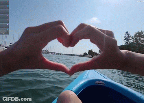 Person In Blue Kayak Making Heart With Fingers GIF