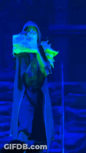 Person In Blue Light Holding I Love You Sign GIF