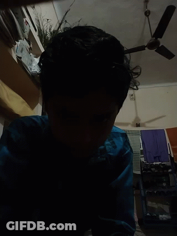 Person In Blue Shirt Standing In Front Of Fan GIF