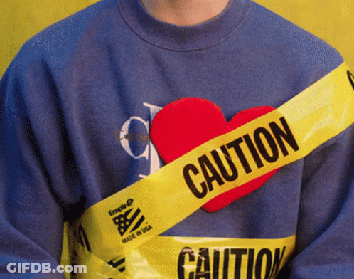 Person In Blue Sweater With Yellow Caution Tape Around Chest GIF