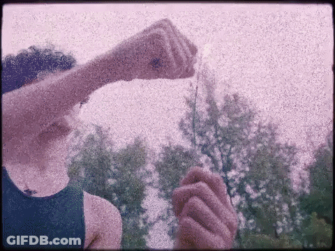 Person In Blue Tank Top Holding Item GIF