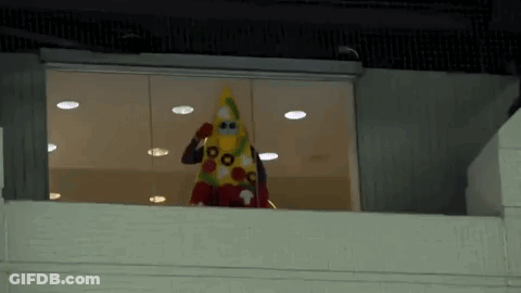 Person In Costume Standing On Balcony Looking Out Window GIF