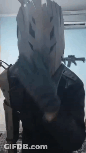 Person In Costume With Gun In Background GIF