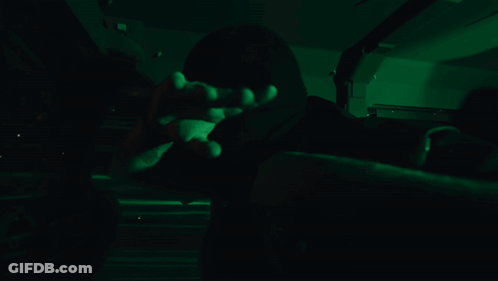 Person In Dark Room With Green Lights On Face GIF