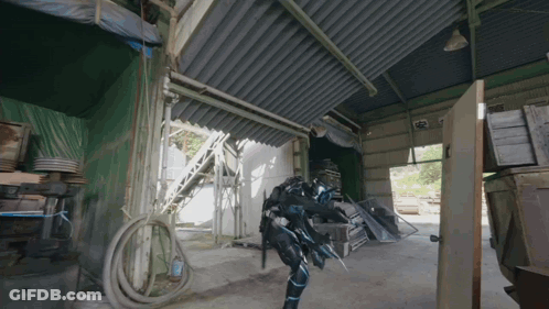 Person In Futuristic Suit Standing In Building GIF