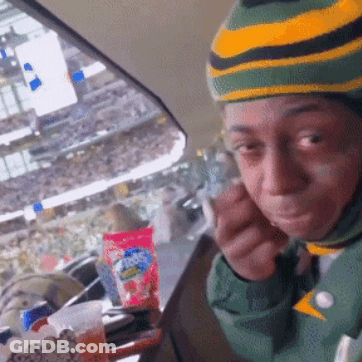 Person In Green And Yellow Striped Hat Eating Snack GIF