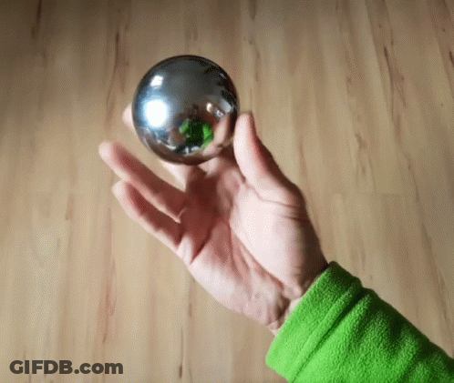 Person In Green Shirt Holding Metal Ball GIF