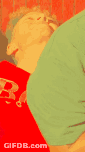 Person In Green Shirt Lying On Red Shirt With Letter B GIF