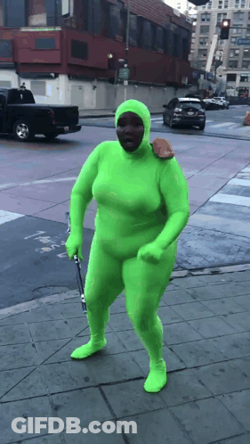 Person In Green Suit Walking Down Street GIF