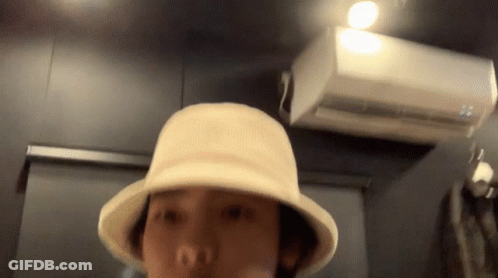 Person In Hat Standing In Front Of White Air Conditioner GIF