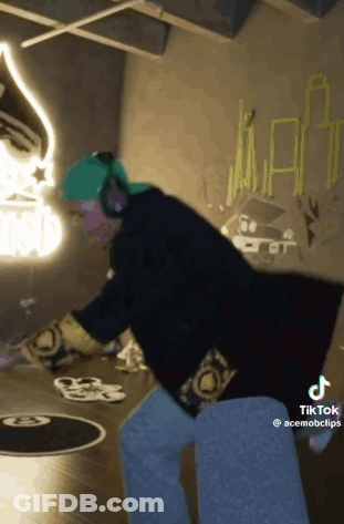 Person In Headphones And Green Hat Dancing In Graffiti Room GIF