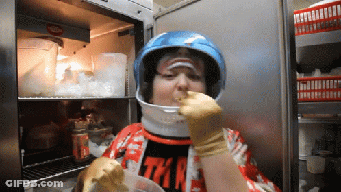 Person In Helmet Eating From Container GIF