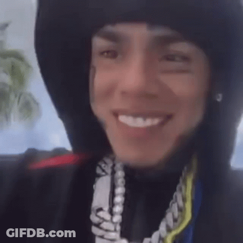 Person In Hoodie And Necklace Smiling GIF
