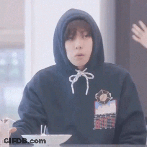 Person In Hoodie Sitting At Table With Bowl Of Food GIF