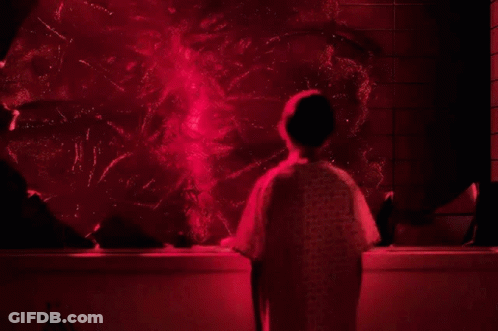 Person In Hospital Gown In Front Of Red Light GIF
