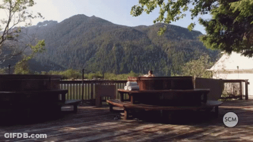 Person In Hot Tub With Mountains And SCM Logo GIF