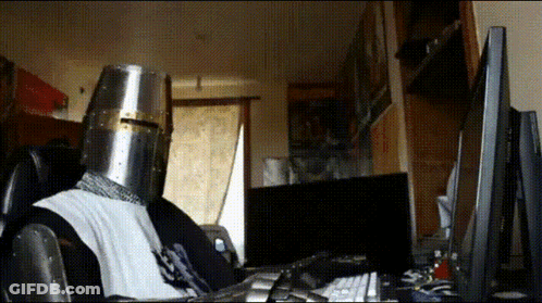 Person In Knight's Helmet At Computer GIF