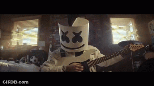 Person In Marshmallow Mask Playing Guitar In Bedroom GIF